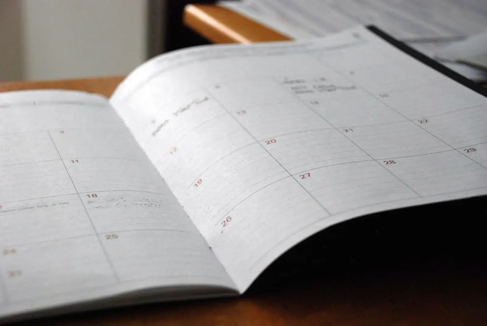 An open monthly planner on a wooden desk.